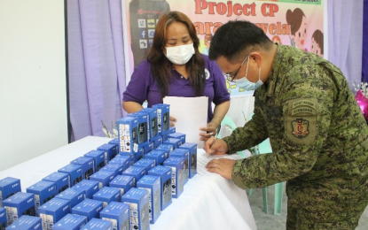 <p><strong>AID TO STUDENTS</strong>. Lt. Col. Rogelio Gabi, the Army’s 40th Infantry Battalion commander, signs the deed of donation for 50 mobile phones to students of the Cotabato City National High School-Annex in Cotabato City on Monday (July 20, 2020) as CCNHS -Annex school headteacher Janette Gaudiano looks on. The phones will be used by students who do not have the means to buy one in their online classes under the 'new normal' mode of learning. <em>(Photo courtesy of 40IB)</em></p>