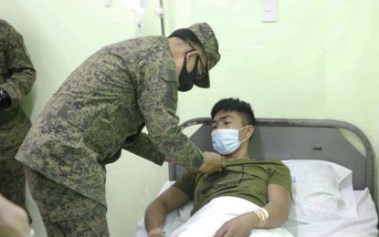 <p><strong>COMMENDED.</strong> Col. George Banzon, commander of the Army's 901st Infantry Brigade, confers Tuesday (July 21, 2020) the 'wounded personnel medal' to one of the wounded soldiers during an encounter with communist rebels in the Surigao del Norte town of Alegria. A female New People's Army rebel was killed during Monday's encounter.<em> (Photo courtesy of 901Bde)</em></p>