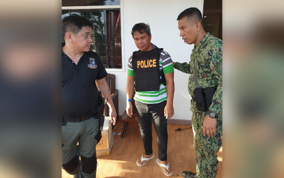 <p><strong>BUSTED.</strong> Kapa Community Ministry founder Joel A. Apolinario (center) is led to a waiting vehicle by Surigao del Sur Provincial Police Office (SDSPPO) chief, Col. James Goforth (right), after his arrest on Tuesday (July 21, 2020) in Barangay Salvacion, Lingig, Surigao del Sur. Victims of Kapa ministry in Caraga Region who poured in millions in pesos of investments want government to make an inventory all the assets, cash and other properties of the ministry and help all the victims get back the money they lost. <em>(Photo courtesy of SDSPPO)</em></p>