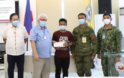 <p><strong>AID FOR REBEL RETURNEES.</strong> Gov. Roberto Uy, chairperson of the Zamboanga del Norte Provincial Task Force to End Local Communist Armed Conflict (2nd from left), leads the distribution of cash assistance Tuesday (July 21, 2020) to former members of the communist New People's Army. Also in photo are Col. Leonel Nicolas, commander of the 102nd Infantry Brigade (2nd from right) and Lt. Col. Jo-ar Herrera, commander of the 53rd Infantry Battalion (right).  <em>(Photo courtesy of the 53rd Infantry Battalion)</em></p>