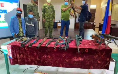 <p><strong>SURRENDER</strong>. One of the 10 surrendering Bangsamoro Islamic Freedom Fighters (right) hands over his rifle to Mayor Salik Mamasabulod during surrender rites inside the town council session hall in Pagalungan, Maguindanao on Friday (July 24, 2020). The surrenderers said they are tired of living a rebel life and wanted much to be with their families again. <em>(Photo courtesy of Pagalungan LGU)</em></p>
