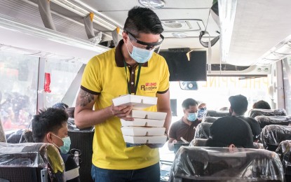 <p><strong>FREE LUNCH.</strong> Representatives of Bounty Agro Ventures Inc. that is behind Uling Roasters, hand out free meals to people who are waiting for their trip back to their home provinces on Sunday (July 26, 2020). Due to the Covid-19 crisis, many people have either been displaced from their jobs or advised to stay at home, prompting them to return to their hometowns. <em>(Contributed photo)</em></p>