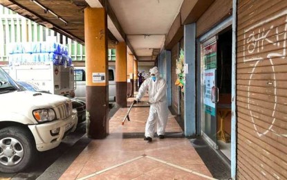 <p><strong>DISINFECTION</strong>. Personnel of the City Disaster Risk Reduction and Management Office (CDRRMO) disinfect the ground floor hallway of the old Bacolod City Hall on July 21, 2020. On Monday (July 27, 2020) the four-story building was locked down after several more employees of the General Services Office occupying the third floor tested positive for coronavirus disease 2019. <em>(Photo courtesy of Bacolod City DRRMO)</em></p>
