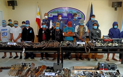 <p><strong>ABANDONING NPA</strong>. The 11 rebels in Eastern Visayas who surrendered to the Philippine National Police and key police officials during a presentation on Monday (July 27, 2020) at the police regional office in Tacloban City. Also in photo are several firearms and ammunition they have turned in to authorities. <em>(PNA photo by Roel Amazona)</em></p>