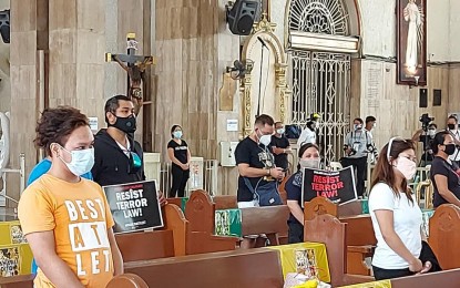 <p><strong>'SILENT PROTEST.'</strong> Akbayan members flash protest placards during a SONA Mass for Peace and Justice on Monday (July 27, 2020) at the Minor Basilica of the Black Nazarene in Quiapo, Manila. The incident angered some netizens and disappointed church officials. <em>(Photo courtesy of Radio Veritas 846)</em></p>