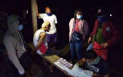 <p><strong>BUSTED.</strong> A team of Philippine Drug Enforcement Agency (PDEA) and police arrests Mohammad Maule (seated, left) in a buy-bust operation Thursday (July 30, 2020) in Tungawan, Zamboanga Sibugay. The suspect has a standing warrant of arrest for the crime of robbery with homicide.<em> (Photo courtesy of PDEA-Zamboanga Sibugay)</em></p>