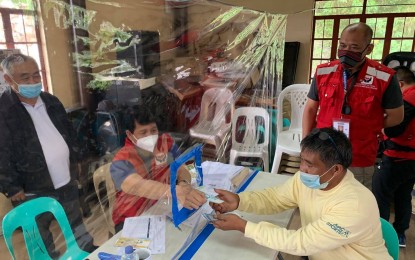 <p><strong>AID FOR THE NEEDY.</strong> Social Welfare Secretary Rolando Bautista personally delivers aid to a beneficiary in La Trinidad, Benguet on Friday (July 31, 2020). The DSWD said it eyes to complete the distribution of the government's emergency subsidies for poor families by August 15. <em>(Photo courtesy of DSWD CAR)</em></p>