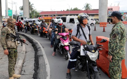 <p><strong>CHECKPOINT.</strong> A queue of motorcyle riders at the quarantine checkpoint along Felix Avenue in Cainta, Rizal. Joint Task Force COVID Shield commander, Lt. Gen. Guillermo Eleazar called on persons with travel exemptions during the modified enhanced community quarantine to not abuse the privilege given them. <em>(PNA photo by Joey O. Razon)</em></p>