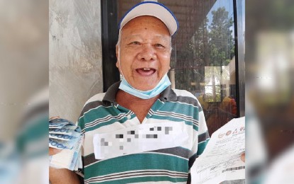 <p><strong>GRATEFUL.</strong> An elderly beneficiary of the government's social amelioration program (SAP) thanks social workers after receiving his PHP6,000 financial aid. He will use the subsidy to buy rice and budget it for his daily expenses. <em>(Photo from DSWD Western Visayas)</em></p>