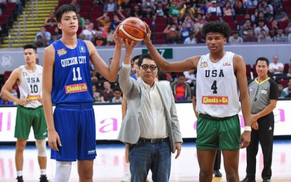 <p><strong>JOINING FORCES</strong>. Jalen Green (right) and Kai Sotto pose for a photo with Bounty Agro Ventures president Ronald Mascarinas during the ceremonial toss of the 2019 NBTC National Finals at the Mall of Asia Arena in Pasay City. Green and Sotto will team up in a select team formed by the NBA G-League as part of its professional pathway program, but they could also be teammates with Gilas Pilipinas Men for the 2023 FIBA World Cup. <em>(Photo courtesy of Chooks-To-Go)</em></p>