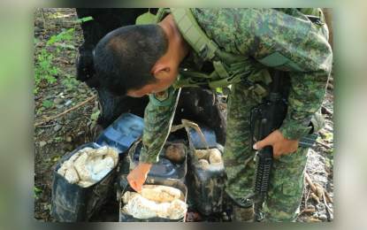 <p><strong>BOMB-MAKING MATERIAL.</strong> A trooper of the Army's 23rd Infantry Battalion inspects the 85 packs of ammonium nitrate placed in plastic containers and concealed by suspected New People’s Army rebels in a remote area of Barangay Maasin, Esperanza, Agusan del Sur. The Army says the recovered bomb-making material pose danger not only to government troops but also to the villagers in the area. <em>(Photo courtesy of 23IB)</em></p>