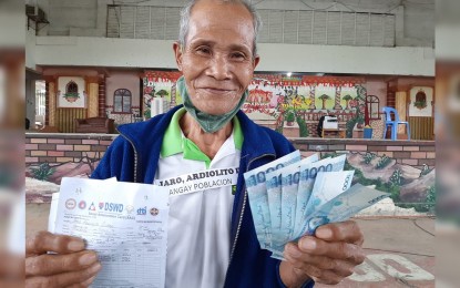<p><strong>SUSTENANCE.</strong> Ardiolito Jaro, 65, a resident of Barotac Viejo in Iloilo, receives the financial aid allotted by the government for his family to cover for the losses of income amid the public health crisis. He is grateful for the cash aid provided by the government as work on the farm failed to sustain the needs of his family during the coronavirus pandemic. <em>(DSWD Western Visayas file photo)</em></p>
