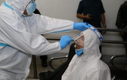 <p><strong>ASG LEADER IN CAMP CRAME.</strong> Abu Sayyaf Group sub-commander Abduljihad Susukan (right) undergoes swab testing for coronavirus disease (Covid-19) upon his arrival in Camp Crame early on Saturday (Aug. 15, 2020). Susukan will be detained at the PNP Custodial Center pending a court order on where he will be detained. <em>(Photo courtesy of PNP PIO)</em></p>