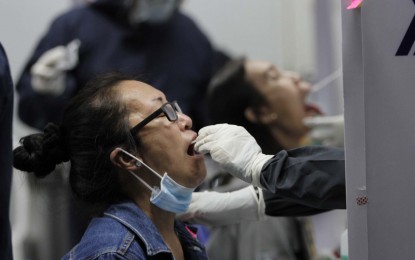 <p><strong>BEWARE.</strong> A woman gets a swab test in this undated photo. Authorities on Thursday (March 25, 2021) warned against unscrupulous individuals who are selling fake Covid-19 test results, mostly to tourists who use the documents as entry requirements or those seeking employment. <em>(PNA file photo)</em></p>