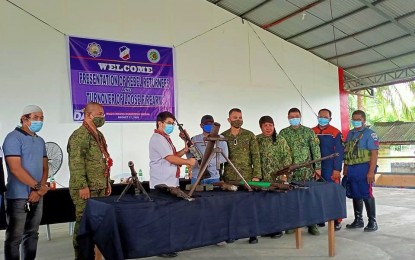 <p><strong>SURRENDER.</strong> One of the 16 surrendering members of the Bangsamoro Islamic Freedom Fighters hands over his rifle to Mayor Datu Pax Ali Mangudadatu (3rd from left) of Datu Abdullah Sangki, Maguindanao during surrender rites held at the town’s multi-purpose hall on Monday (Aug. 17, 2020). The former rebels said they wanted to start life anew with their families after getting tired of always being on the run from military forces.<em> (Photo courtesy of DAS LGU)</em></p>