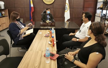 <p><strong>TOURISM RECOVERY</strong>. Department of Tourism (DOT)-Central Visayas regional head Shalimar Hofer Tamano (right, in white) talks with Lapu-Lapu City Mayor Junard Chan (center) on the revival plan of the tourism industry in the island destination. Hotels and resorts in the city are expected to reopen next month. <em>(Photo courtesy of Lapu-Lapu City PIO)</em></p>