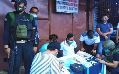 <p><strong>BUSTED DUO.</strong> Anti-narcotics agents in the Bangsamoro Autonomous Region in Muslim Mindanao conduct an inventory of the items seized from two suspects (in handcuffs) during anti-drug operations in Balindong, Lanao del Sur on Wednesday (Aug. 19, 2020). The confiscated illegal drugs have an estimated street value of PHP2 million. <em>(Photo courtesy of PDEA-BARMM)</em></p>