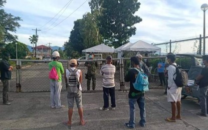 <p><strong>TEMPORARY ZONING CONTAINMENT</strong>. Captain Ferdinand Usita, Baler town chief of police, talks with employees of the ZF Construction regarding the temporary zoning containment at Aurora Trading Center in Sitio Setan, Barangay Calabuanan on Thursday (Aug. 27, 2020). The zoning scheme was imposed after those who came in contact with the town's second coronavirus case was brought to the area for isolation. <em>(Photo courtesy of the Baler Police Station)</em></p>