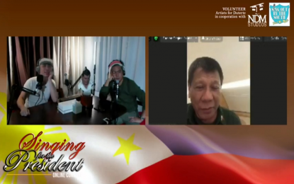 <p><strong>SINGING FOR THE PRESIDENT.</strong> President Rodrigo Duterte briefly appears in a virtual concert held for him hosted by singer Jimmy Bondoc (green shirt) and writer-director and singer-songwriter Njel de Mesa (white shirt) on Sunday (Aug. 30, 2020). Duterte said he will visit victims of the twin blasts that rocked Jolo, Sulu last Sunday. <em>(Screenshot from Sing Out by the South)</em></p>