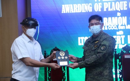 <p><strong>APPRECIATION.</strong> AFP chief-of-staff Lt. Gen. Gilbert Gapay (right) gives a plaque of appreciation to San Miguel Corp. (SMC) president and chief operating officer Ramon Ang, represented by his vice president and special assistant, retired Col. Ariel Querubin (left) in a ceremony in Camp Aguinaldo, Quezon City on Tuesday (Sept. 1, 2020). The SMC previously donated to the Department of National Defense and the AFP construction materials and amenities intended for the installation of emergency quarantine facilities in military camps nationwide. <em>(Photo courtesy of AFP Public Affairs Office)</em></p>