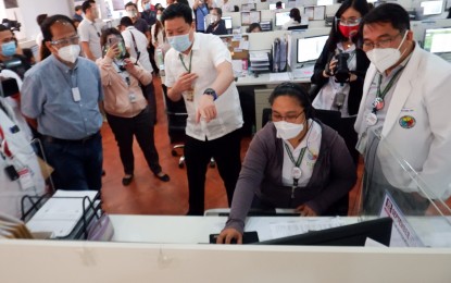 <p><strong>MEGA CONTACT TRACING CENTER.</strong> Valenzuela Mayor Rex Gatchalian (center, in barong) shows Chief Implementer of the country's National Policy Against Covid-19, Secretary Carlito Galvez Jr. (left, in blue polo shirt) how their contact tracing system works, at the Social Hall of the Valenzuela City Hall on Tuesday (Sept. 1, 2020). The city implements a “contactless” system that enables contact tracers to attend to emails on all incoming and outgoing requests and queries and call those possibly exposed to the virus.<em> (PNA photo by Robert Oswald P. Alfiler)</em></p>