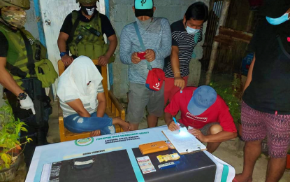 <p><strong>DRUG BUST.</strong> A female teacher from Maguindanao suspected of peddling illegal drugs in Cotabato City covers her face with a white cloth as an anti-narcotics agent account the suspected shabu drugs amounting to PHP40,000 seized from her possession on Monday (Aug. 31, 2020). The teacher’s husband, who managed to escape, is being tracked down by a joint team of Philippine Drug Enforcement Agency and police operatives. <em>(Photo courtesy of PDEA-BARMM)</em></p>