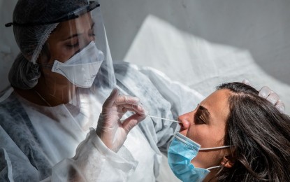 <p><strong>SWAB TEST.</strong> A medical worker wearing protective equipment takes a swab sample from a woman for a Covid-19 PCR test at a temporary screening center in front of the City Hall of Paris, France on Aug. 31, 2020. Global Covid-19 deaths surpassed 850,000 on Tuesday (Sept. 1, 2020). <em>(Photo by Aurelien Morissard/Xinhua)</em></p>