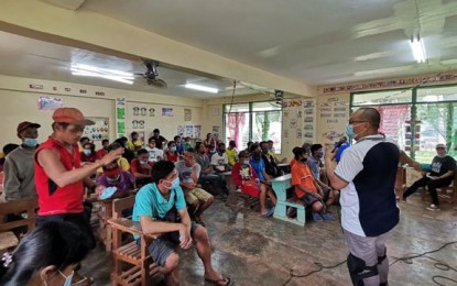<p><strong>AID FOR EX-REBELS.</strong> Department of Agriculture-Region 9 executive director Ran Donn Cedeño (standing, right) holds dialogue with residents, including former communist New People's Army (NPA) terrorists, Friday in Barangay Guibo, Siayan, Zamboanga del Norte. Cedeño led the distribution of livestock and vegetable seeds as well as encourages the former NPAs to engage in community backyard gardening. <em>(Photo courtesy of Department of Agriculture regional office)</em></p>