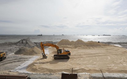 <p><strong>‘WHITE SAND’ BEACH</strong>. Works continue even on a Sunday (Sept. 6, 2020) as an excavator spreads the synthetic sand along the shoreline of Manila Bay as part of the ongoing efforts to beautify the bayfront under the Manila Bay Rehabilitation Program. Presidential spokesperson Harry Roque on Monday said the project will prevent soil erosion and flooding. <em>(PNA photo by Avito C. Dalan)</em></p>