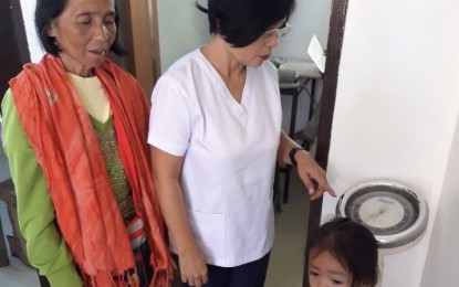 <p><strong>HEALTH MONITORING</strong>. Undated photo shows Evelyn Fijo (center), midwife at the Estaca and Buenasuerte Health Stations in Pilar town, Bohol, checking the weight of a 4Ps monitored child. The Department of Social Welfare and Development (DSWD) in Central Visayas on Wednesday (Sept. 10, 2020) said it will resume monitoring the health conditions of 4Ps beneficiaries to ensure they are safe from  Covid-19 and other public health threats.<em> (Photo courtesy of DSWD-7)</em></p>