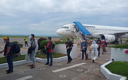 <p><strong>REPATRIATED.</strong> Overseas Filipino workers line up after alighting from an airplane in Eastern Visayas in this undated photo. The Department of Transportation (DOTr) on Friday (Dec. 18, 2020) said the government's 'Hatid-Tulong' program has so far brought home 373,293 OFWs.<em> (PNA file photo)</em></p>