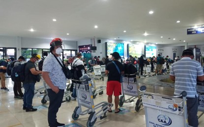<p><strong>BACK HOME</strong>. Repatriated overseas Filipino workers wait for their luggage upon arrival at the Tacloban City airport in this Aug. 30, 2020 photo. The city government of Calbayog in Samar has issued an executive order allowing home quarantine for returning overseas Filipinos starting Dec. 6, 2020. <em>(Photo courtesy of Civil Aviation Authority of the Philippines)</em></p>