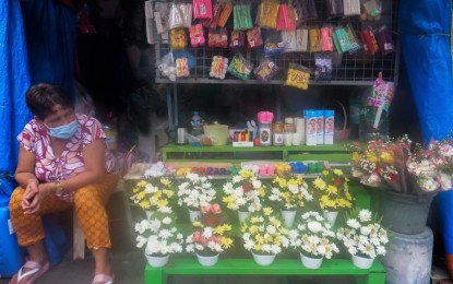 <p><strong>REMEMBERING THE DEPARTED.</strong> A vendor sells candles and flowers in her store outside the Bagbag Cemetery in Novaliches, Quezon City on Sept. 15, 2020. Filipinos have shifted to either visiting their departed loved ones ahead of the 'Undas' holidays or simply remember them through hearing Mass or praying at home as the government ordered the closure of all cemeteries, memorial parks and columbariums in the country from October 29 to November 4. <em>(PNA photo by Robert Oswald Alfiler)</em></p>