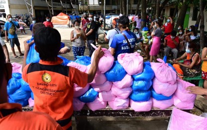 <p><strong>AID TO FIRE VICTIMS.</strong> A personnel from the office of Davao City 1st District Rep. Paolo 'Pulong' Duterte distributes food packs on Tuesday afternoon (Sept. 15, 2020) to the fire victims in Barangay Leon Garcia, Agdao District. At least 129 families or 350 individuals were affected after some 60 houses and seven classrooms of a public school in the village were razed by a fire on September 3.<em> (Photo courtesy of Rep. Paolo Duterte's office)</em></p>