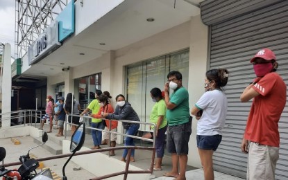 <p><strong>HEALTH PROTOCOL</strong>. Undated photo shows bank clients observing physical distancing while lining up to withdraw money from an automated teller machine at the Philippine National Bank in Minglanilla, Cebu. The Cebu Bankers Club on Friday (Sept. 18, 2020) said banks in Cebu are safe from Covid-19 with measures put in place to ensure the safety of personnel and clients.<em> (PNA photo by John Rey Saavedra)</em></p>