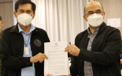 <p><strong>CLEARED.</strong> Cabinet Officer for Security and Development for Western Visayas, Roy Cimatu (left) and Department of the Interior and Local Government (DILG) regional head Juan Jovian Ingeniero (right) present two approved resolutions declaring 86 barangays in the region as cleared of the influence of the communist terrorist group (CTG) during the RTF-ELCAC meeting on Sept. 9. A total of 160 barangays in the region have been cleared of the CTG influence.<em> (Photo courtesy of DENR 6)</em></p>