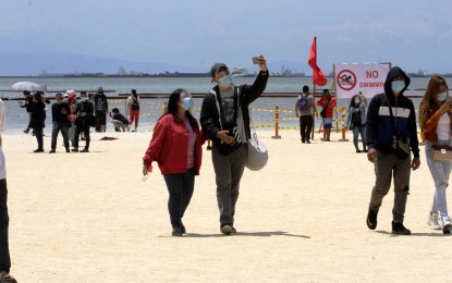 <p><strong>SELFIE BY THE BAY.</strong> People take selfies at Manila Bay’s “white sand beach” on Sunday (Sept. 20, 2020). Crowds wait in long lines to step on the beach which has been temporarily reopened to the public. <em>(PNA photo by Avito Dalan)</em></p>