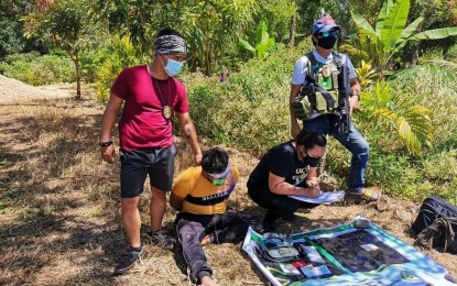 <p><strong>NABBED.</strong> Drug suspect Hasanor Moctar (seated on ground) looks on as an anti-narcotics agent accounts for the seized shabu items from him worth PHP353,600 during a drug sting operation in Banisilan, North Cotabato on Sunday (Sept. 20, 2020). Also seized from the suspect were the marked money and documents associating himself with the Moro Islamic Liberation Front. <em>(Photo courtesy of PDEA-12)</em></p>