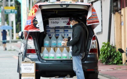 <p><strong>STRICTER PERSONAL HYGIENE.</strong> A man sells bottles of alcohol from the trunk of his car. The ongoing Covid-19 pandemic has prompted many Filipinos to be “cleaner than clean” to avoid contracting the disease. <em>(PNA file photo by Joey Razon)</em></p>