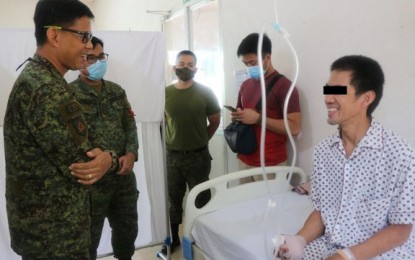 <p><strong>CARING FOR WOUNDED REBEL.</strong> Lt. Col. Jo-ar Herrera, commander of the Army's 53rd Infantry Battalion (left), and Rowel Monasque, a New People's Army (NPA) leader (right,) share a light moment during the Army official's visit to the wounded NPA leader at Camp Major Cesar Sang-an Station Hospital  in Labangan, Zamboanga del Sur on Friday (Sept. 25, 2020. The 53IB is providing medical care assistance to Monasque, who was wounded in the Sept. 21 clash in Barangay Marangan, Dumingag, Zamboanga del Sur. <em>(Photo courtesy of the 53IB)</em></p>