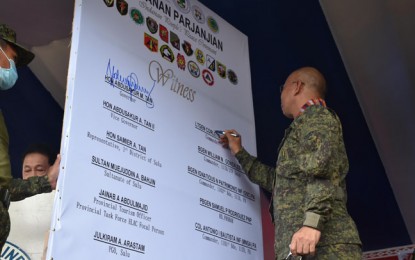 <p><strong>PEACE COVENANT.</strong> Lt. Gen. Corleto Vinluan Jr., commander of the Western Mindanao Command, joins the peace covenant signing Tuesday (Sept. 29, 2020) declaring the Abu Sayyaf Group bandits as persona non grata in the municipality of Indanan, Sulu. Indanan Mayor Hermot Jikiri leads the activity, participated by military, police, and local government officials. <em>(Photo courtesy of Westmincom Public Information Office)</em></p>