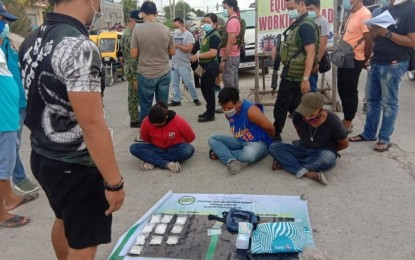 <p><strong>BUSTED.</strong> The three handcuffed drug suspects sit on the ground following their arrest in Barangay Poblacion, Pikit, North Cotabato, on Thursday afternoon (Oct. 1, 2020). Seized from them were PHP3.4-million worth of suspected shabu, a .45-caliber pistol, and a motorcycle, authorities say. <em>(Photo courtesy of PDEA-BARMM)</em></p>