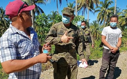 <p><strong>ROAD PROJECT.</strong> Col. Emerito Pineda, commander of the Army's 547th Engineer Battalion, discusses the benefits of the road project to the community to former Datu Tutukan barangay chairperson Roque Galcon Jr. (left) and Labangon Barangay chairperson Fermin Anggi (right) in the Dumingag, Zamboanga del Sur. Army officials say the construction of more roads in the area would further pressure communist rebels. <em>(PNA photo by Leah D. Agonoy)</em></p>