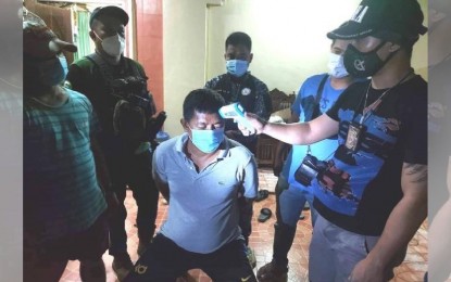 <p><strong>COLLARED.</strong> An anti-narcotics agent checks on the body temperature of drug suspect Nashrudin Kasan Roup, 45 of Barangay Poblacion Mother, Cotabato City who was arrested Monday dawn (Oct. 5, 2020) in a drug buy-bust operation. Seized from him were suspected shabu with an estimated street value of PHP340,000 and an unlicensed .45-caliber pistol. <em>(Photo courtesy of PDEA-BARMM)</em></p>