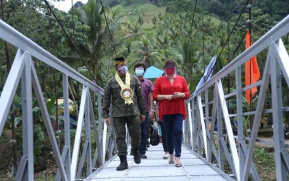 <p><strong>TOWARDS DEVELOPMENT.</strong> AFP chief-of-staff Gen. Gilbert Gapay (left) and GMA Kapuso Foundation (KF) executive vice president and chief operating officer Rikki Escudero-Catibog (right) walk through a 40-meter hanging bridge turned over by the AFP and GMA KF to the municipal government of Salvador, Lanao del Norte on Friday (Oct. 9, 2020). Aside from the bridge, two classrooms with comfort rooms constructed by troops at the Pamsur Primary School would benefit around 200 students. <em>(Photo courtesy of AFP Public Affairs Office)</em></p>