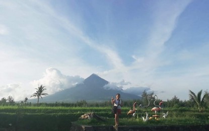 <p><strong>AGRI-TOURISM</strong>. A boy poses for a shot with Mt. Mayon in the background in an agri-tourism site in Daraga, Albay. Fe Buela, Department of Tourism-Bicol officer-in-charge, on Wednesday (Oct. 21, 2020) said they will soon reopen over a hundred tourism sites to visitors from outside the region. <em>(Photo by Connie Calipay)</em></p>