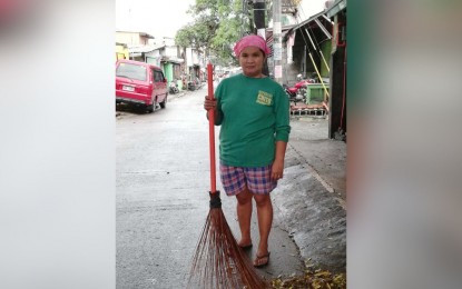 <p><strong>STRUGGLING</strong>. Connie Ceroma-Mawa, 42, a street sweeper in Quezon City. She hopes the pandemic ends soon so that she can look for a better job and adequately provide for her family. <em>(Photo by Joanne Villanueva)</em></p>