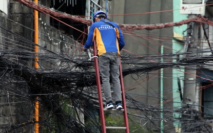<p>A Globe personnel working on an electric pole. <em>(Photo courtesy of Globe)</em></p>