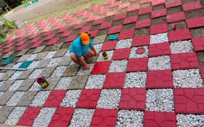 <p><strong>'ECO-BRICKS'.</strong> A worker paints eco-tile bricks made of plastic waste materials in this undated photo. Personnel from the Luzong National High School in Pagudpud, Ilocos Norte recycle their plastic wastes and turns them into eco-bricks to be used for school beautification purposes while some are sold to the community.<em> (Photo courtesy of Thelma Ruiz-Sacsac)</em></p>