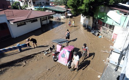 <p><strong>AFTERMATH.</strong> Residents of Felicidad Village-3 in Barangay Banaba in San Mateo, Rizal walk on mud left by floods from Typhoon Ulysses on Friday (Nov. 13, 2020). The NDRRMC said 14 deaths linked to the typhoon's onslaught are being validated. <em>(PNA photo by Joey O. Razon)</em></p>
